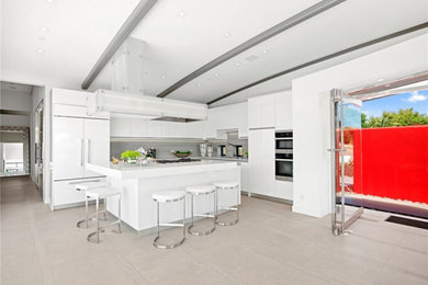 Photo of a mid-sized modern l-shaped open plan kitchen in Other with a double-bowl sink, flat-panel cabinets, white cabinets, quartz benchtops, white splashback, porcelain splashback, stainless steel appliances, porcelain floors, with island, grey floor, white benchtop and exposed beam.