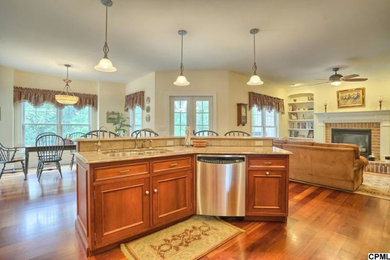 Eat-in kitchen - large modern galley medium tone wood floor eat-in kitchen idea in Other with a double-bowl sink, raised-panel cabinets, medium tone wood cabinets, granite countertops, multicolored backsplash, stone tile backsplash, stainless steel appliances and an island