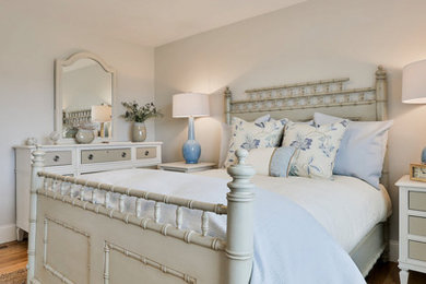 Example of a mid-sized transitional guest light wood floor and brown floor bedroom design in Boston with gray walls and no fireplace