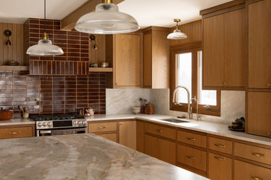 Example of a kitchen design in Minneapolis with flat-panel cabinets, medium tone wood cabinets and an island