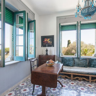 Bild på ett eklektiskt hemmabibliotek, med vita väggar, klinkergolv i keramik, ett fristående skrivbord och flerfärgat golv