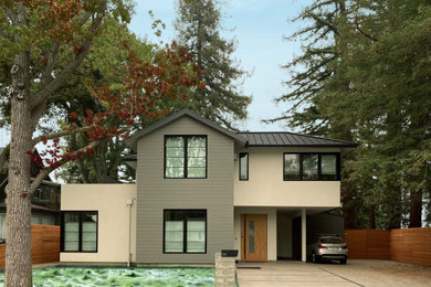Aménagement d'une grande façade de maison grise classique en bois à un étage avec un toit à deux pans, un toit en métal et un toit noir.