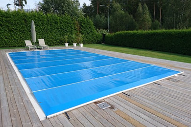 Immagine di una grande piscina nordica rettangolare dietro casa con pedane