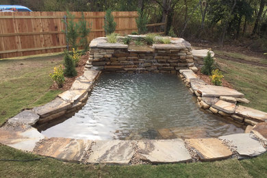 Photo of a large rustic partial sun backyard stone landscaping in Other.