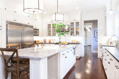 Example of a transitional u-shaped eat-in kitchen design in Portland with a farmhouse sink, shaker cabinets, white cabinets, quartzite countertops, white backsplash, subway tile backsplash and stainless steel appliances