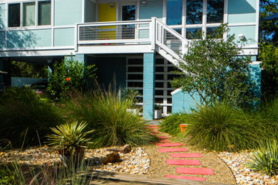 Photo of a mid-sized contemporary front yard full sun xeriscape with a garden path and river rock.