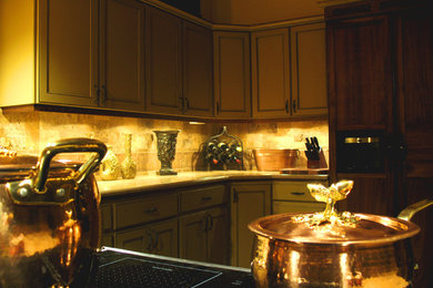 Example of a large classic u-shaped open concept kitchen design with an undermount sink, recessed-panel cabinets, beige cabinets, granite countertops, multicolored backsplash, stone tile backsplash, black appliances and a peninsula