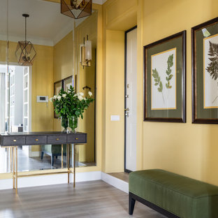 Свежая идея для дизайна: входная дверь среднего размера в стиле современная классика с желтыми стенами, полом из ламината, одностворчатой входной дверью, белой входной дверью и бежевым полом - отличное фото интерьера