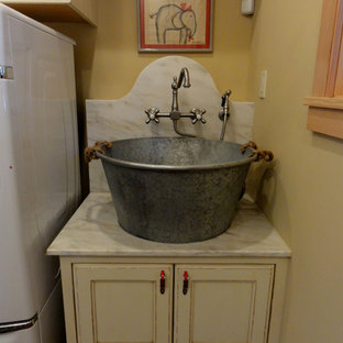 Design ideas for a medium sized country utility room in Boise with distressed cabinets, marble worktops, a side by side washer and dryer and recessed-panel cabinets.