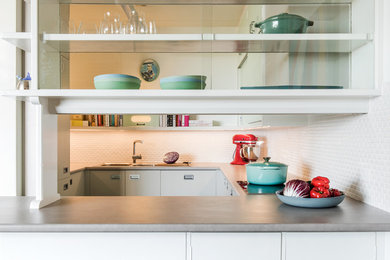 Design ideas for a midcentury kitchen in Other with a double-bowl sink, flat-panel cabinets, turquoise cabinets, laminate benchtops, white splashback, subway tile splashback, black appliances, linoleum floors, turquoise floor and grey benchtop.