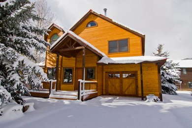 Large brown three-story wood exterior home idea in Denver