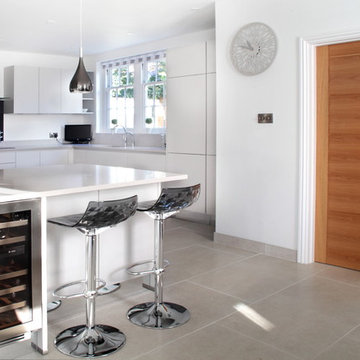 Light grey handle-less kitchen with breakfast bar
