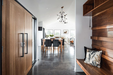 Ispirazione per una sala da pranzo aperta verso la cucina minimalista di medie dimensioni con pareti grigie, pavimento in cemento e pavimento grigio