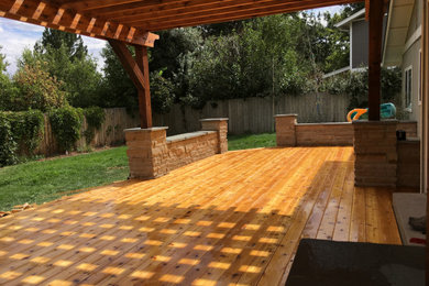 Deck - mid-sized craftsman backyard ground level deck idea in Denver with a pergola