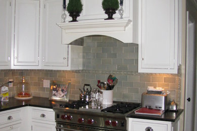 Example of a large transitional single-wall eat-in kitchen design in New York with raised-panel cabinets, white cabinets, gray backsplash, subway tile backsplash and stainless steel appliances