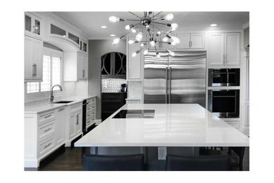 Inspiration for a large transitional l-shaped dark wood floor and brown floor eat-in kitchen remodel in Kansas City with a single-bowl sink, flat-panel cabinets, white cabinets, quartz countertops, white backsplash, marble backsplash, stainless steel appliances, an island and white countertops