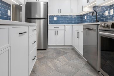 Mid-sized minimalist u-shaped gray floor kitchen photo in DC Metro with an undermount sink, shaker cabinets, white cabinets, quartz countertops, blue backsplash, ceramic backsplash, stainless steel appliances, no island and white countertops