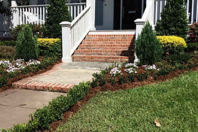 Photo of a mid-sized traditional full sun front yard formal garden for summer.