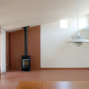 Inspiration för ett mellanstort funkis separat vardagsrum, med ett finrum, vita väggar, tegelgolv, en öppen vedspis, en spiselkrans i tegelsten och brunt golv