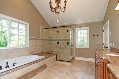 Inspiration for a traditional master bathroom in New York with medium wood cabinets, a drop-in tub, a corner shower, beige tile, beige walls, travertine floors, an undermount sink and a hinged shower door.