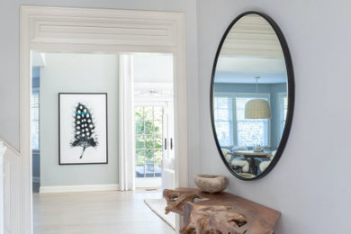 Imagen de distribuidor abovedado actual de tamaño medio con paredes blancas, suelo de madera clara, puerta simple, puerta azul, suelo beige y machihembrado