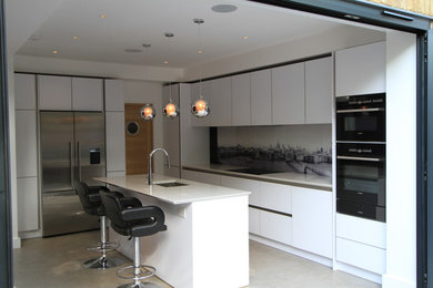 Photo of a large contemporary l-shaped open plan kitchen in London with a single-bowl sink, flat-panel cabinets, white cabinets, quartz worktops, white splashback, glass sheet splashback, porcelain flooring, an island and stainless steel appliances.
