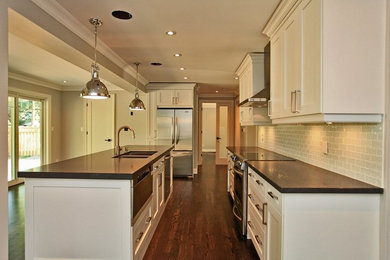 Example of a large classic l-shaped dark wood floor and brown floor eat-in kitchen design in Toronto with a double-bowl sink, shaker cabinets, white cabinets, granite countertops, blue backsplash, glass tile backsplash, stainless steel appliances and an island