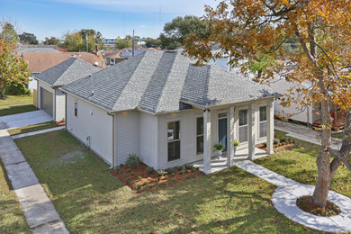 Mid-sized transitional beige one-story concrete fiberboard house exterior idea in New Orleans with a hip roof and a shingle roof