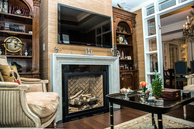 Family room - traditional enclosed family room idea in Toronto with beige walls, a standard fireplace, a wood fireplace surround and a wall-mounted tv