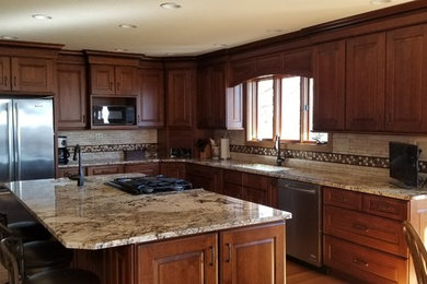 Elegant medium tone wood floor kitchen photo in Other with a double-bowl sink, granite countertops and stainless steel appliances