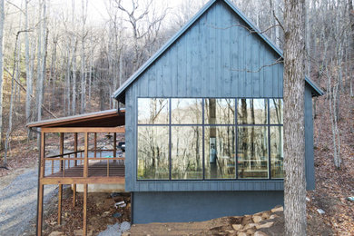 Ejemplo de fachada de casa azul y negra tradicional renovada de tamaño medio de dos plantas con revestimiento de madera, tejado a dos aguas, tejado de metal y panel y listón