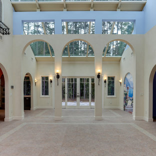 Imagen de salón abierto, mediterráneo, grande, sin chimenea y televisor, con paredes multicolor, suelo vinílico y suelo beige