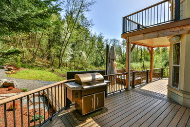Inspiration for a large contemporary backyard deck in Seattle with a roof extension.