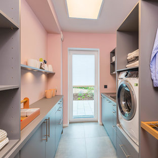 Inspiration for a medium sized contemporary galley utility room in Other with a built-in sink, flat-panel cabinets, grey cabinets, pink walls, grey floors and grey worktops.
