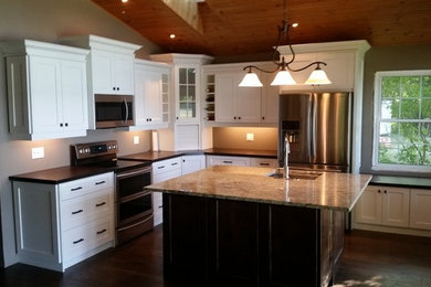 Inspiration for a transitional l-shaped medium tone wood floor open concept kitchen remodel in Toronto with an undermount sink, shaker cabinets, wood countertops, stainless steel appliances and an island