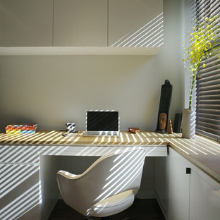 This is an example of a modern home office and library in New York with a built-in desk.