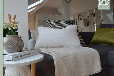 Esempio di un piccolo soggiorno scandinavo aperto con libreria, pareti bianche, parquet chiaro e parete attrezzata