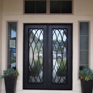 Foto di un piccolo ingresso o corridoio chic con pavimento in cemento, una porta a due ante, una porta in metallo e pareti beige