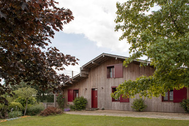 Cette photo montre une façade de maison nature en bois et bardeaux de taille moyenne avec un toit à deux pans.