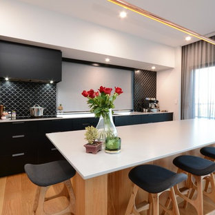 Modern kitchen pantry designs - Minimalist light wood floor and brown floor kitchen pantry photo in Hobart with a drop-in sink, black cabinets, quartz countertops, black backsplash, ceramic backsplash, black appliances, an island and white countertops