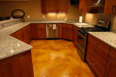 Enclosed kitchen - mid-sized u-shaped concrete floor enclosed kitchen idea in Detroit with shaker cabinets, dark wood cabinets, stainless steel appliances and no island