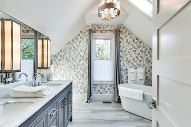 Inspiration for a large transitional master gray tile and limestone tile limestone floor and gray floor freestanding bathtub remodel in Toronto with furniture-like cabinets, gray cabinets, a two-piece toilet, white walls, an undermount sink, quartz countertops and a hinged shower door