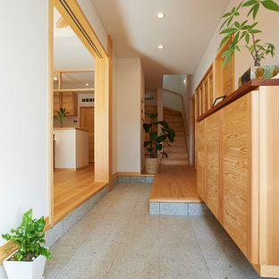 Design ideas for an asian entryway in Other with white walls and grey floor.