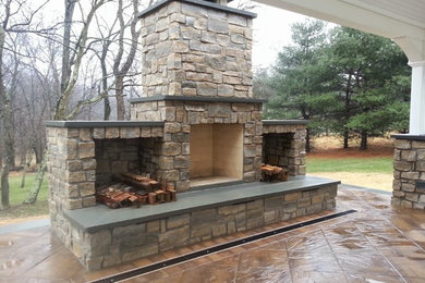 This is an example of a mid-sized traditional backyard patio in Baltimore with a fire feature, stamped concrete and a gazebo/cabana.
