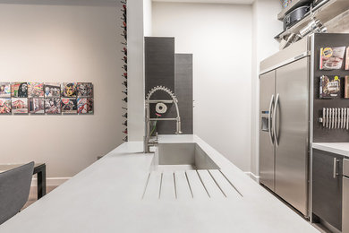 Inspiration for a mid-sized contemporary galley medium tone wood floor eat-in kitchen remodel in Miami with an integrated sink, flat-panel cabinets, dark wood cabinets, concrete countertops, brick backsplash, stainless steel appliances and a peninsula