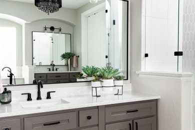 Example of a mid-sized transitional master white tile and mosaic tile porcelain tile, gray floor, double-sink and wainscoting bathroom design in Dallas with recessed-panel cabinets, gray cabinets, a two-piece toilet, gray walls, an undermount sink, quartz countertops, a hinged shower door, white countertops, a niche and a built-in vanity