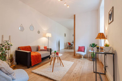 Cette image montre une salle de séjour design ouverte avec parquet clair.