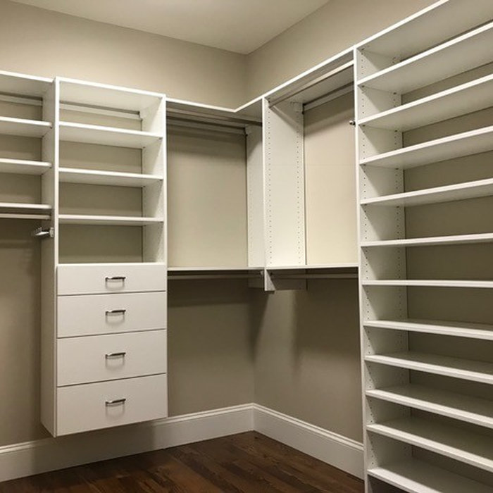 This is a large walk-in closet with a great storage design! There are flat panel dove tailed drawers in a unit with adjustable shelves above. There are several areas of both double and single chrome h