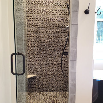 Shower design done with penny rounds on the accent wall and shower floor