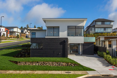 Design ideas for a large modern two-storey brown exterior in Auckland with wood siding.